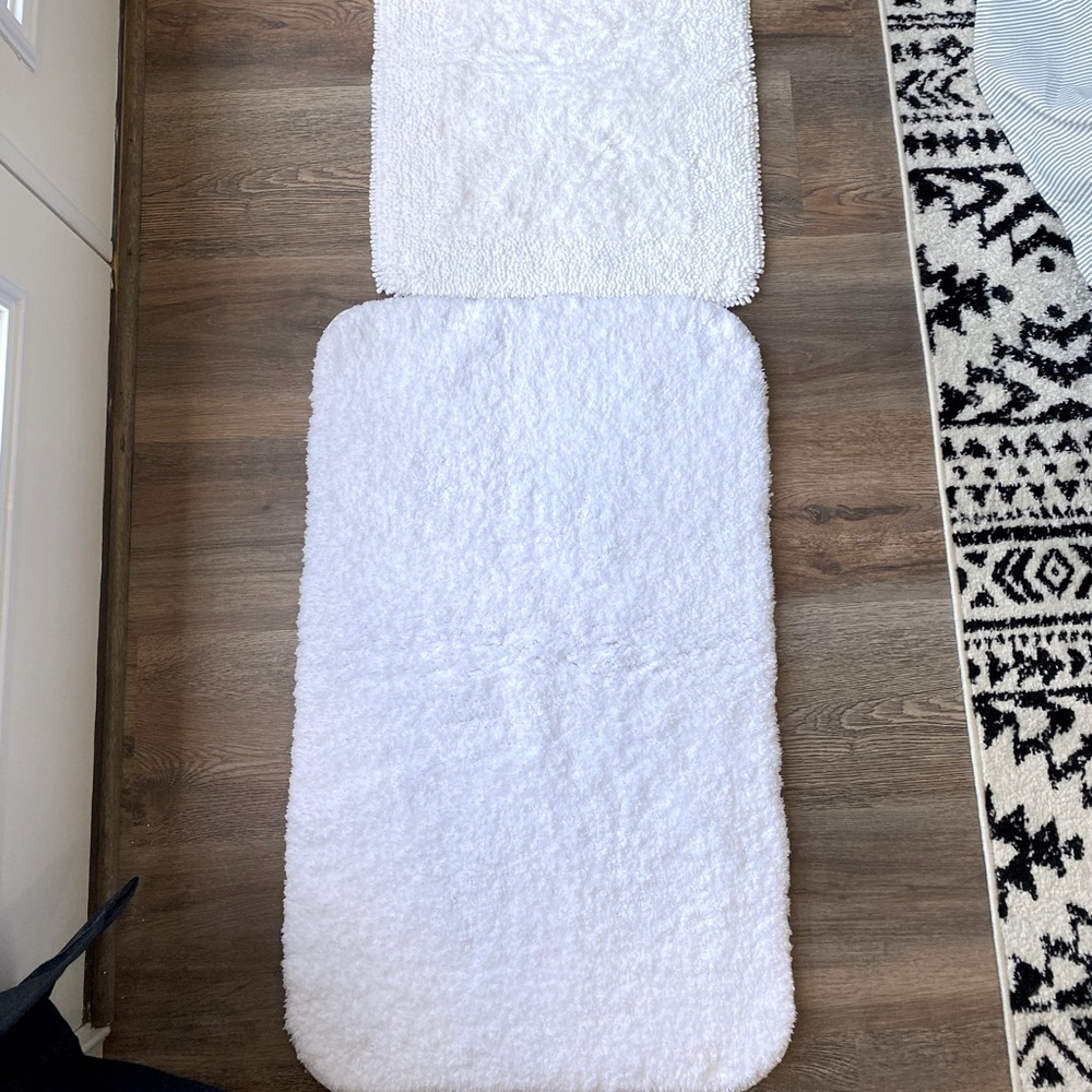 Two white bath rugs